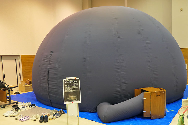 空気が入った半球型の灰色のテントのような移動式プラネタリウムの写真
