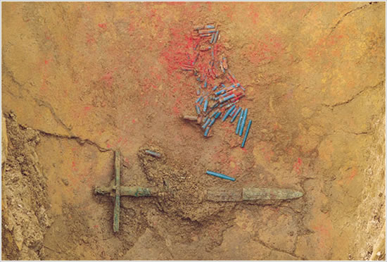 写真：吉野ヶ里遺跡北墳丘墓第1002号甕棺出土の有柄細形銅剣とガラス玉